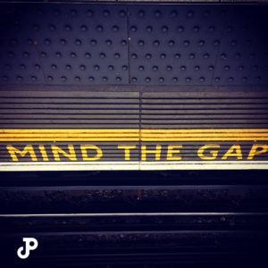 A photo of a London train station that reads, Mind the Gap