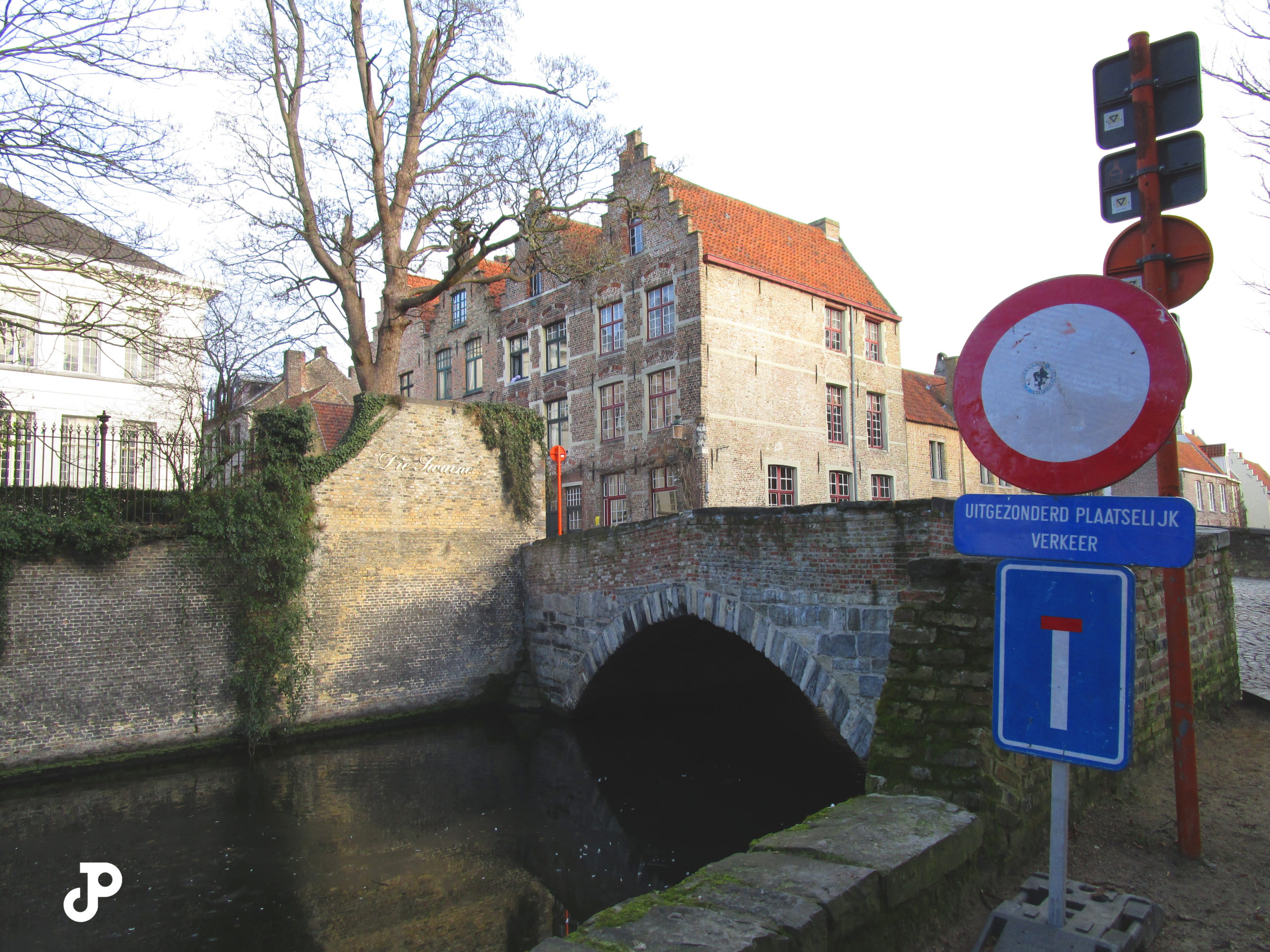 a brick bridge spanning a narrow canal