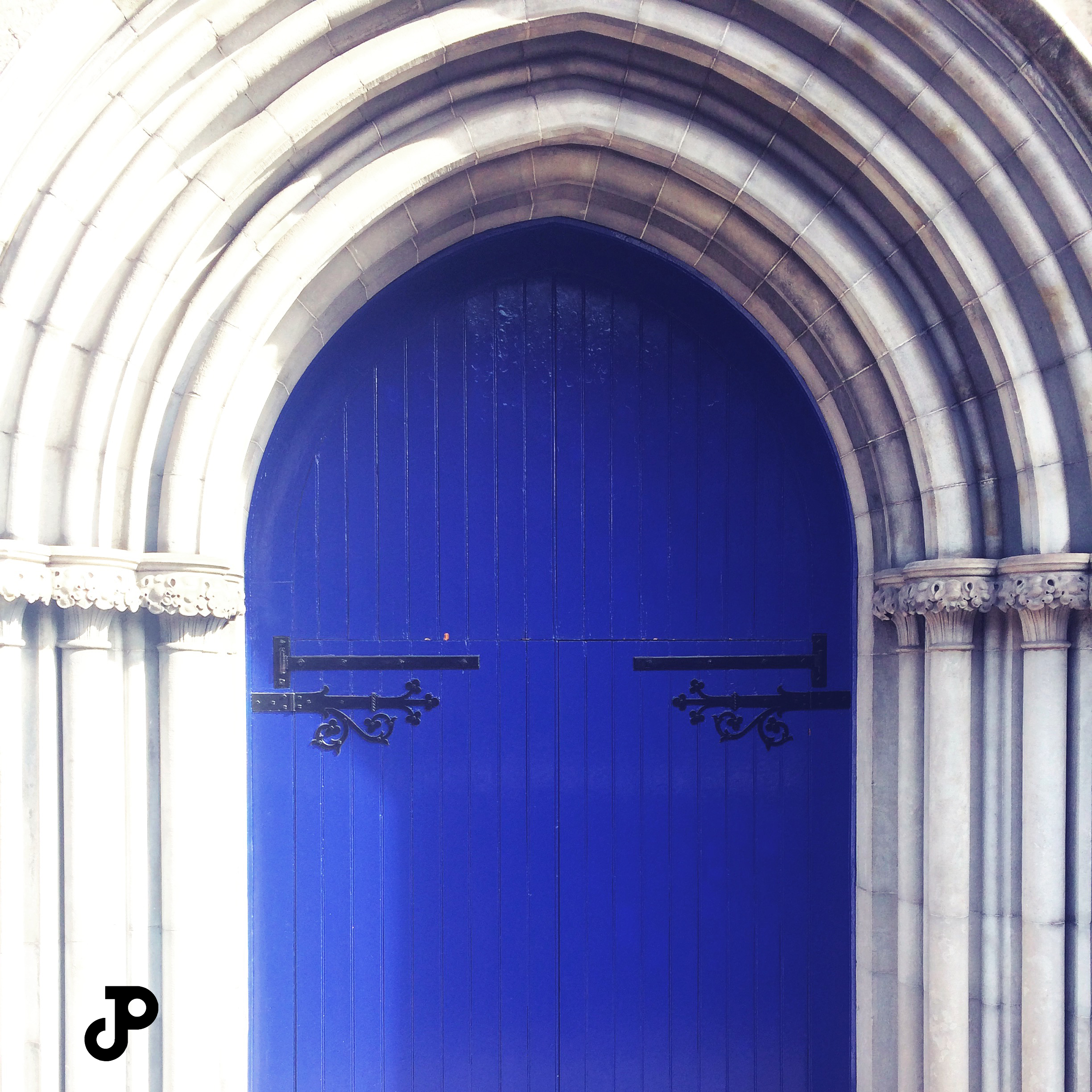 an arching, medieval door, painted a vibrant shade of blue, at Saint Patrick's Cathedral