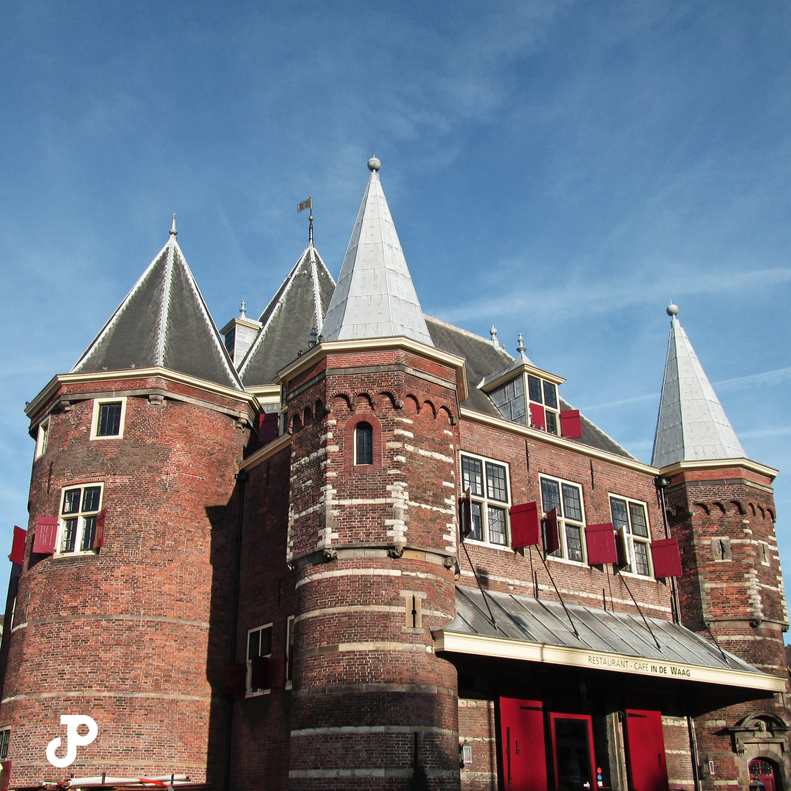 a medieval brick building with red shutters and pointed rooves