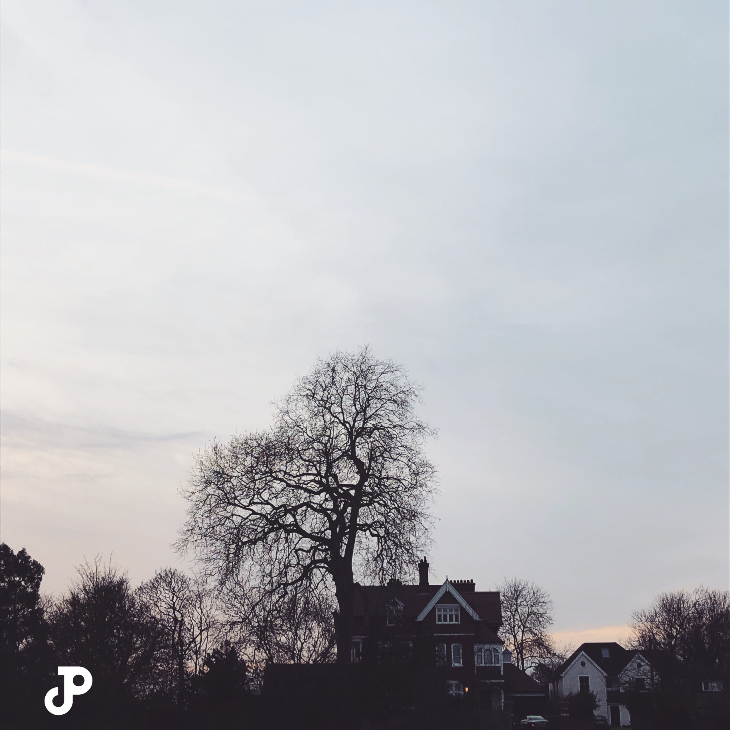 the silhouettes of a cottage and tree at twilight in Kingston Upon Thames