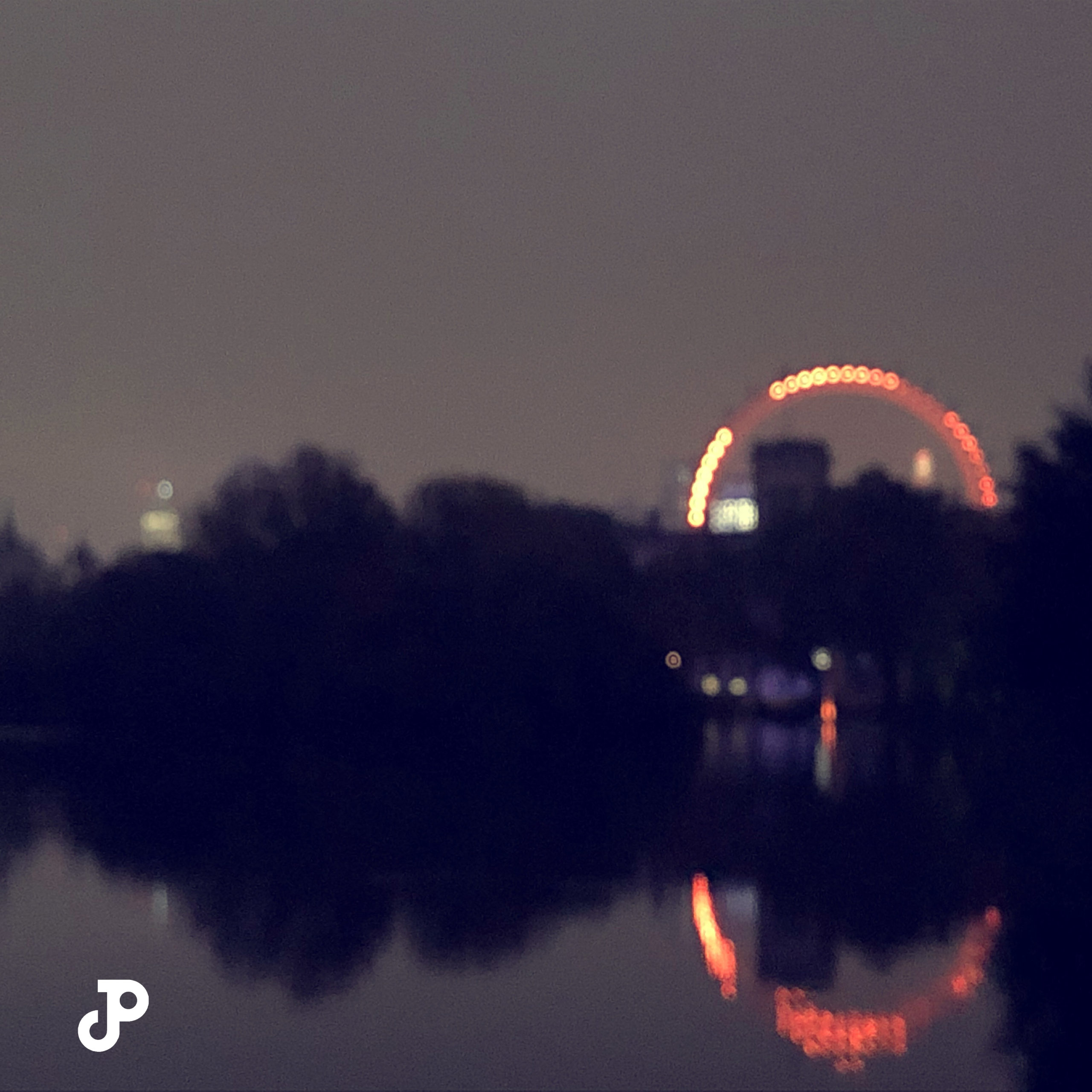 a blurred view of the London Eye seen from Saint James Park at twilight