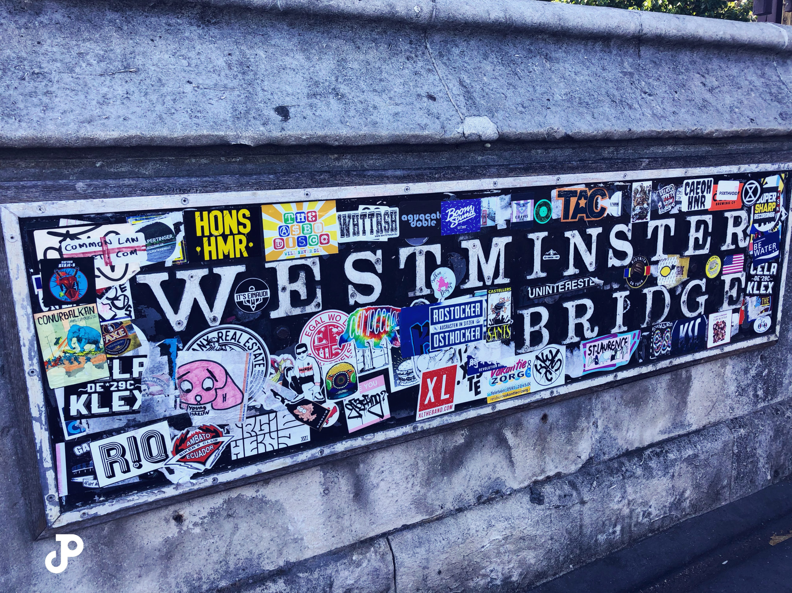 a sticker-covered sign that reads Westminster Bridge