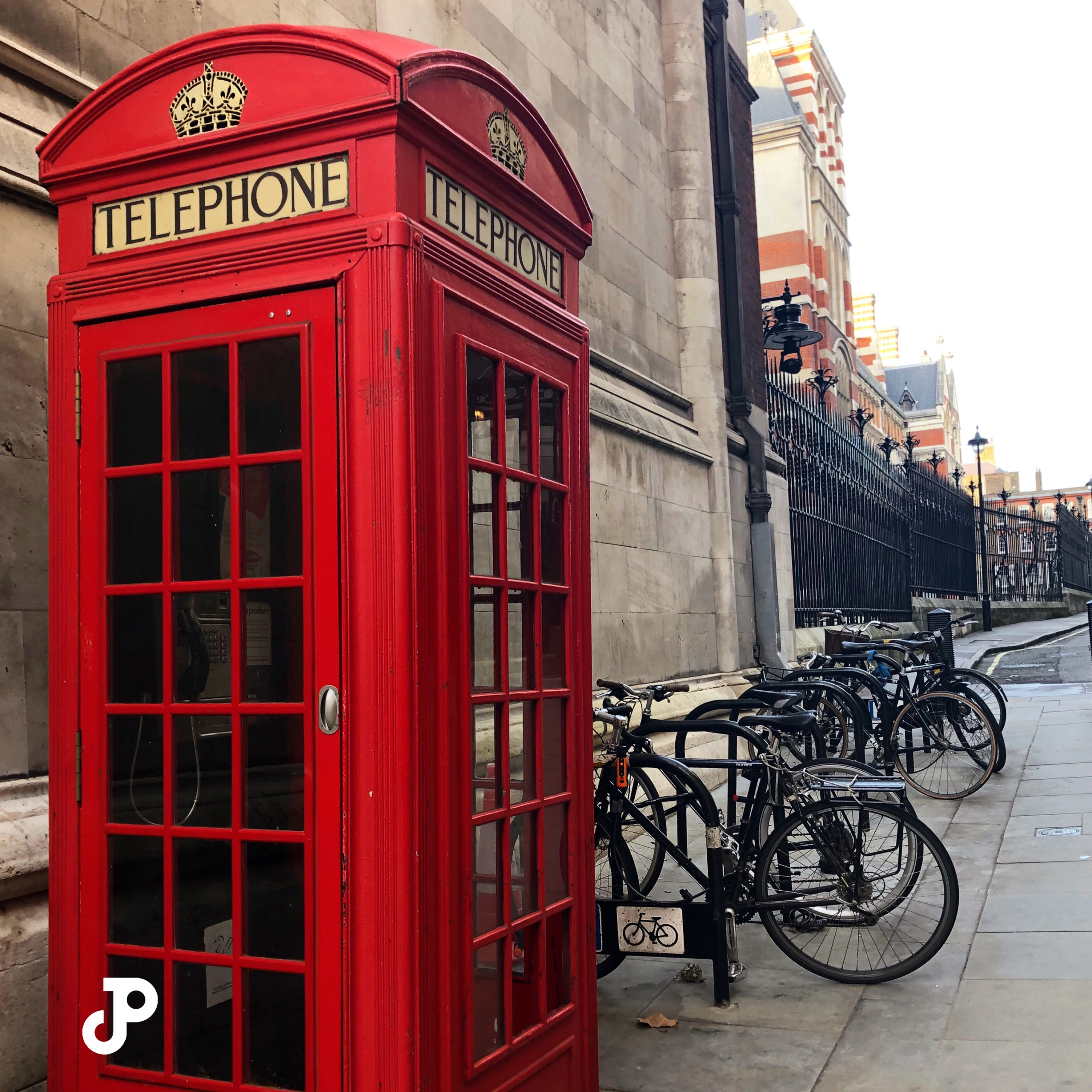 a red phone booth beside a row of bicycles in London