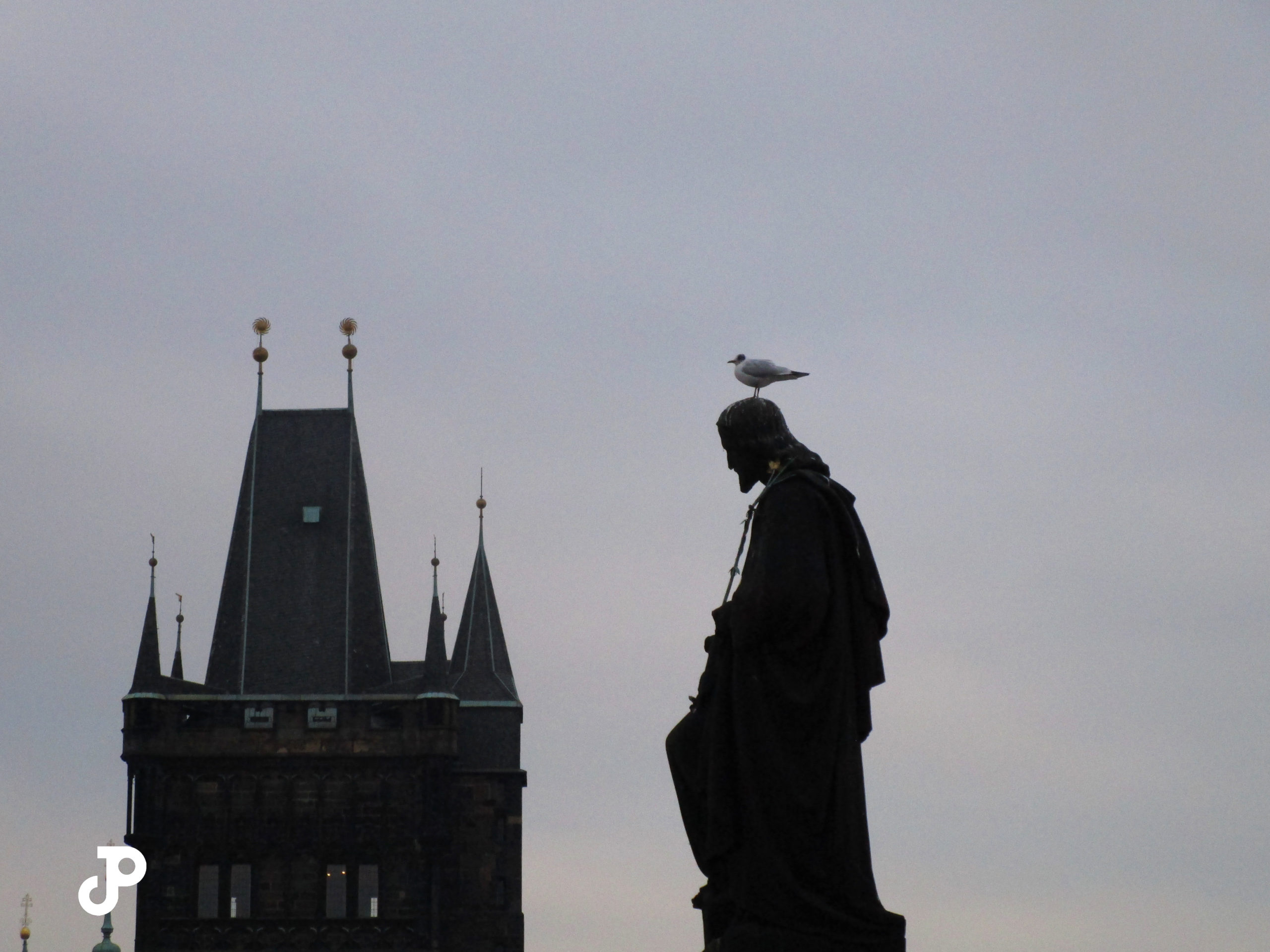 a silhouette of a statue with a sea bird resting on its head