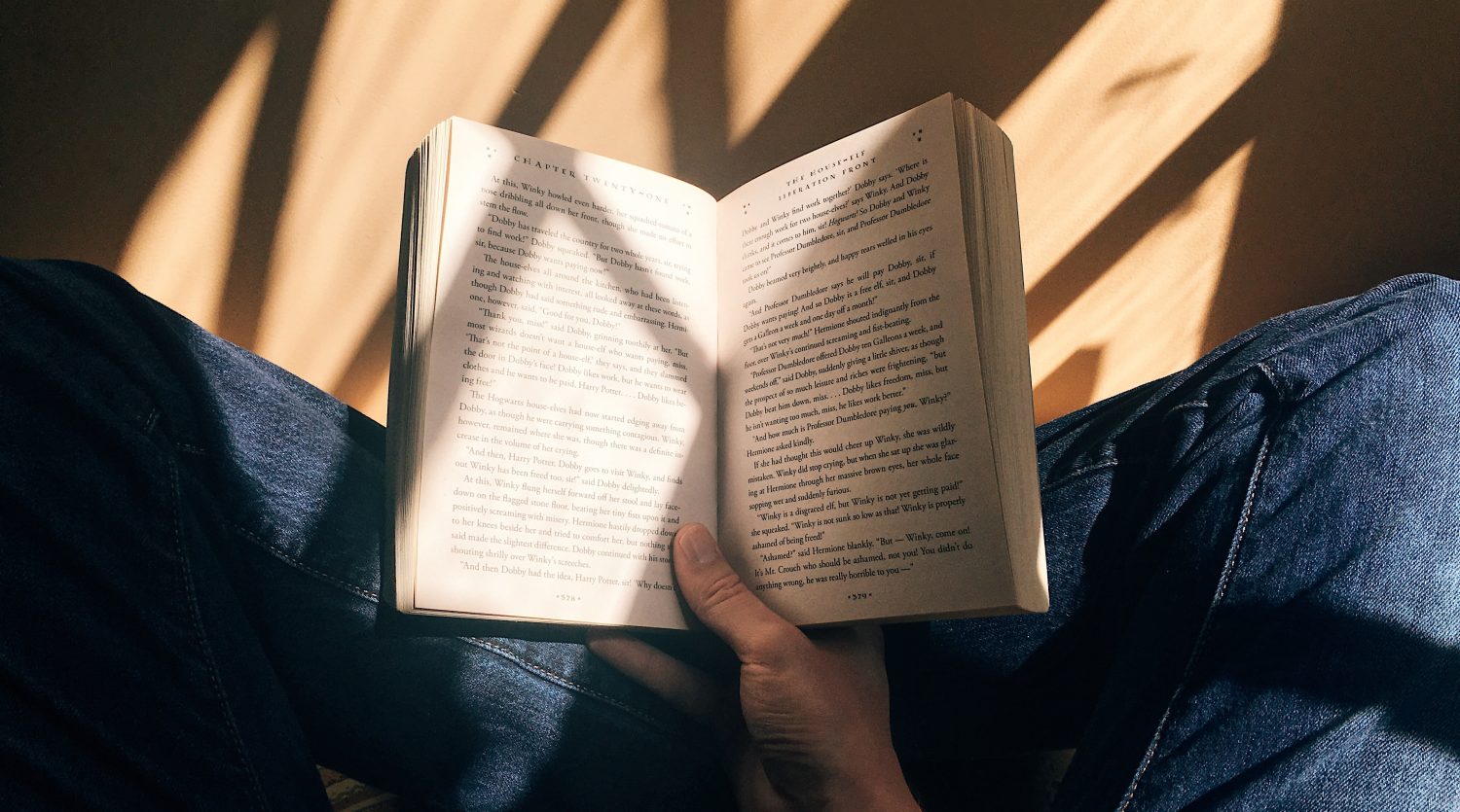 A print book being held open by two hands